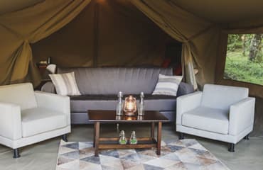 Lounge seating inside an executive safari tent